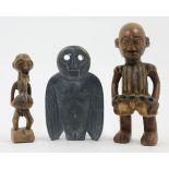 Two African carved hardwood figures, 20th century, depicting a prisoner standing with chains arou...