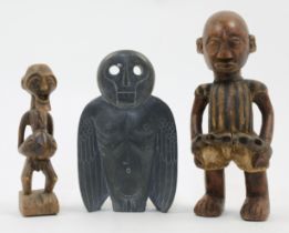 Two African carved hardwood figures, 20th century, depicting a prisoner standing with chains arou...