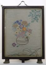 An English embroidery converted to a fire screen, early 20th century, depicting a vase of colourf...