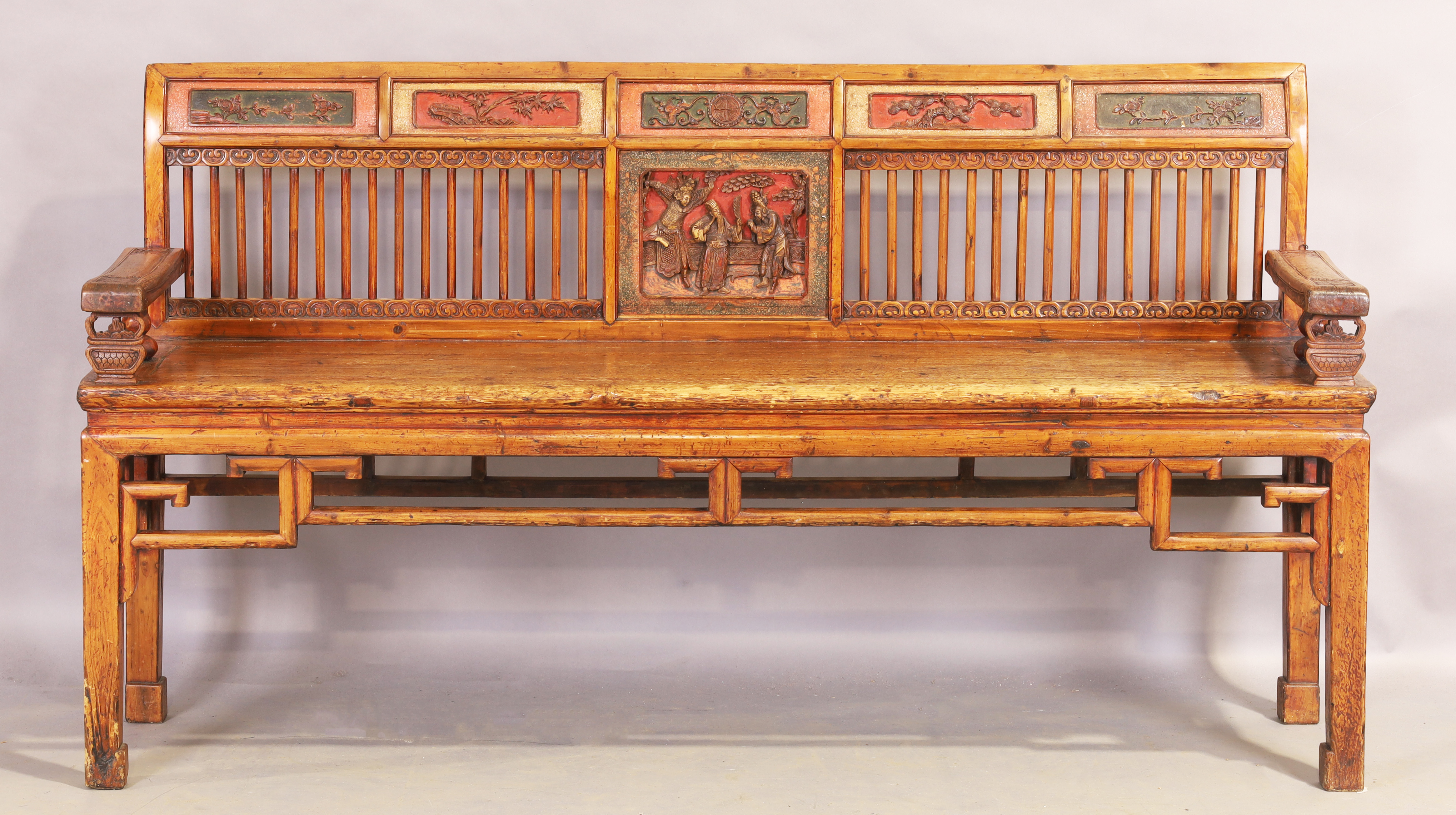 A Chinese hardwood bench, first quarter 20th century, the stick back with carved panels and part ...