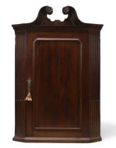A George III mahogany corner cupboard, last quarter 18th century, the moulded and dentil swan nec...