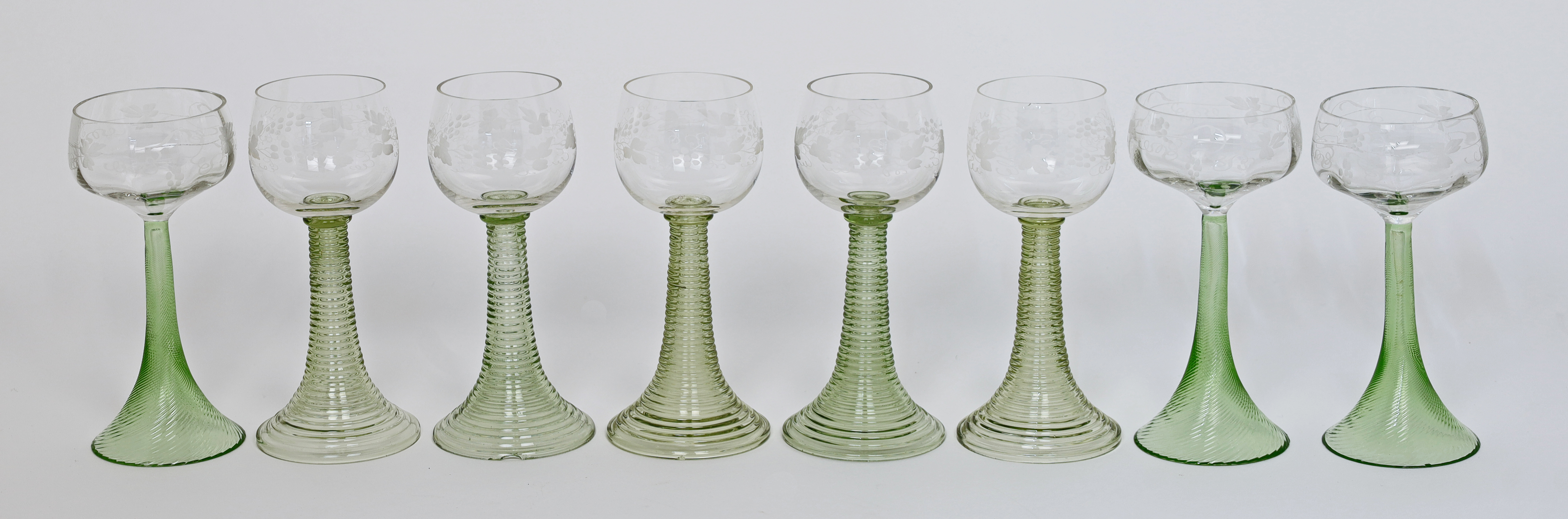 A group of Continental hock glasses, 20th century, the clear bowls with grape and vine decoration...