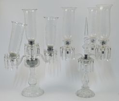 Two cut and moulded glass three-light candelabras with glass shades, 20th century, the first of S...