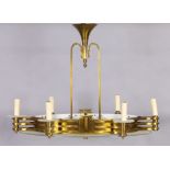 An Art Deco brass and frosted glass eight-light chandelier, 20th century, the oval brass frame wi...