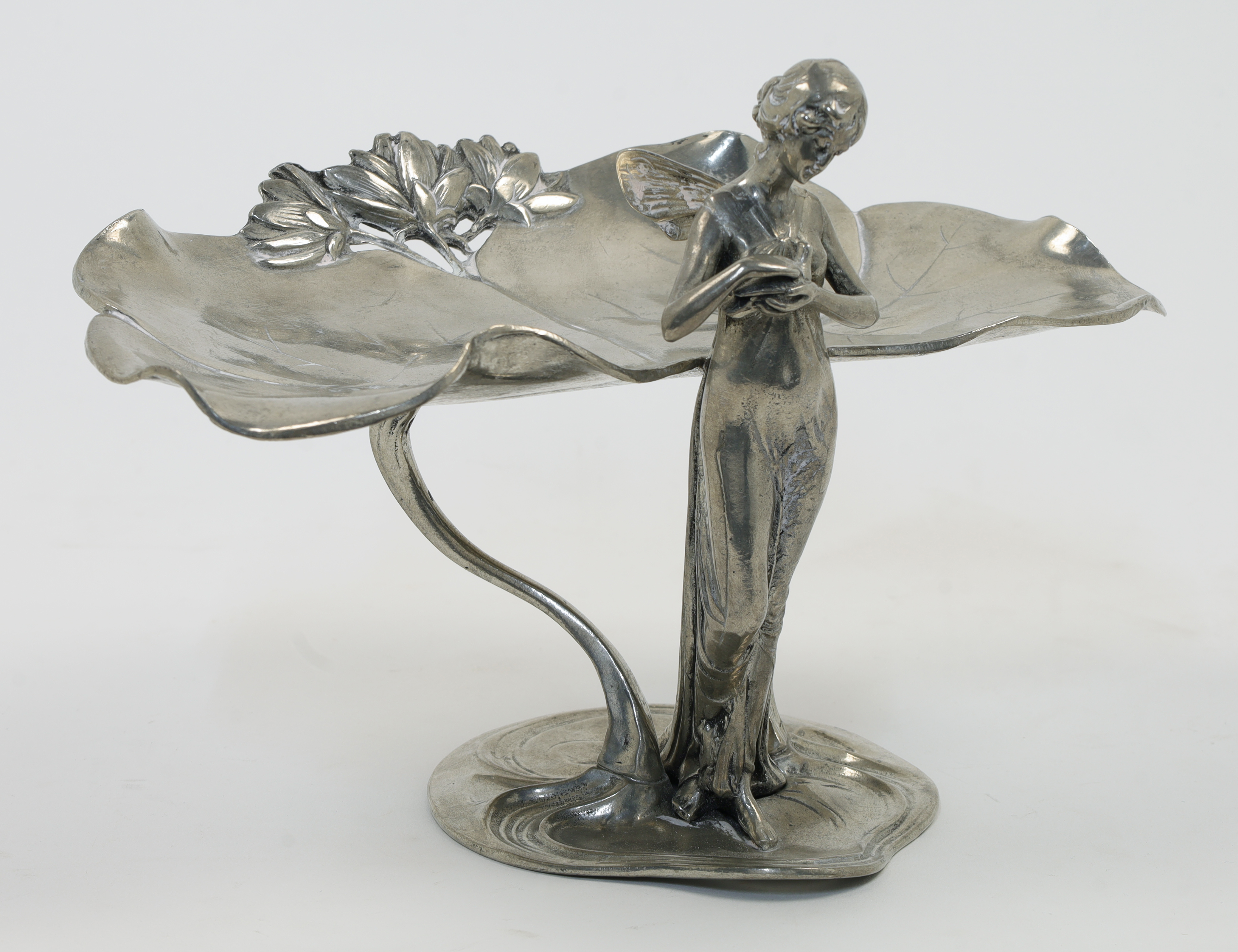 An Art Nouveau style silvered metal card tray, 20th century, modelled as a fairy holding a dove w...