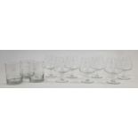 A set of seven French engraved brandy glasses, 20th century, each with stylised decoration of a t...