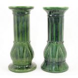 A near pair of West German green majolica jardiniere stands, 20th century, of columnar form with ...