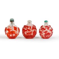 Three Chinese red overlay translucent and snowstorm glass snuff bottles Qing dynasty, 19th centu...