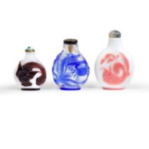 Three Chinese overlay glass snuff bottles Late Qing dynasty - 20th century Comprising: a pink o...