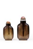 Two Chinese smoky quartz snuff bottles Qing dynasty, 19th century Both well-hollowed from dark,...