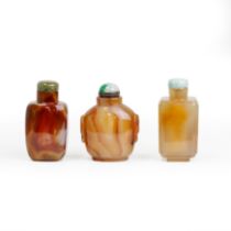 Three Chinese agate snuff bottles Qing dynasty, 19th century Comprising: a translucent caramel-...