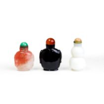 Three Chinese glass snuff bottles Late Qing dynasty Comprising: a white glass imitating jade do...
