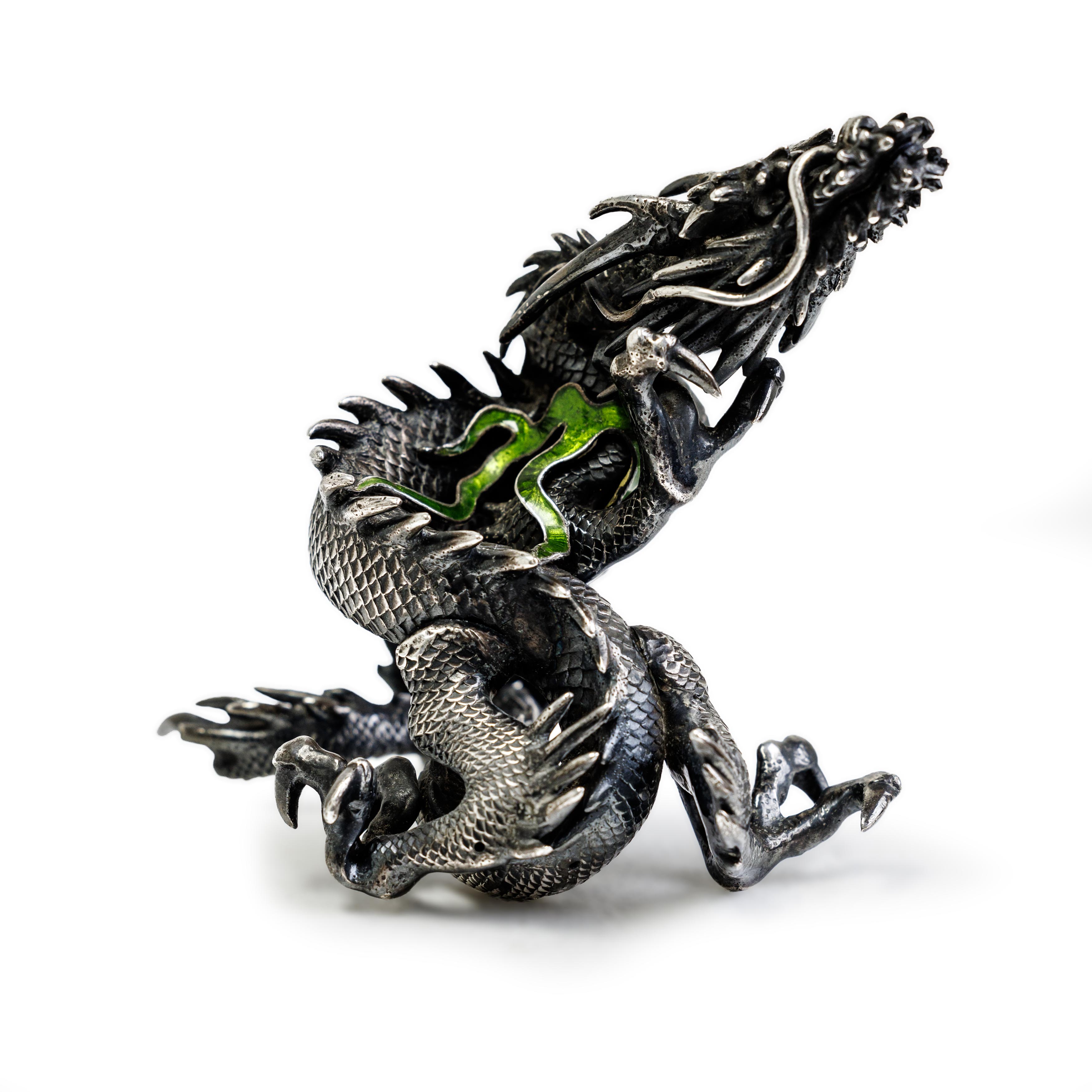 A Japanese white metal and enamel okimono of a dragon Meiji period, unmarked The beast tightly ...
