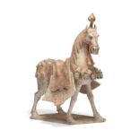 A Chinese painted pottery figure of a caparisoned horse Northern Qi dynasty Modelled powerfully...