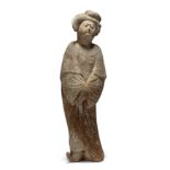 A Chinese painted pottery figure of a court lady Tang dynasty Standing slightly swaying, her ha...