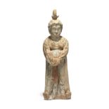 A Chinese pottery figure of a court lady Tang dynasty Modelled standing wearing a voluminous ro...