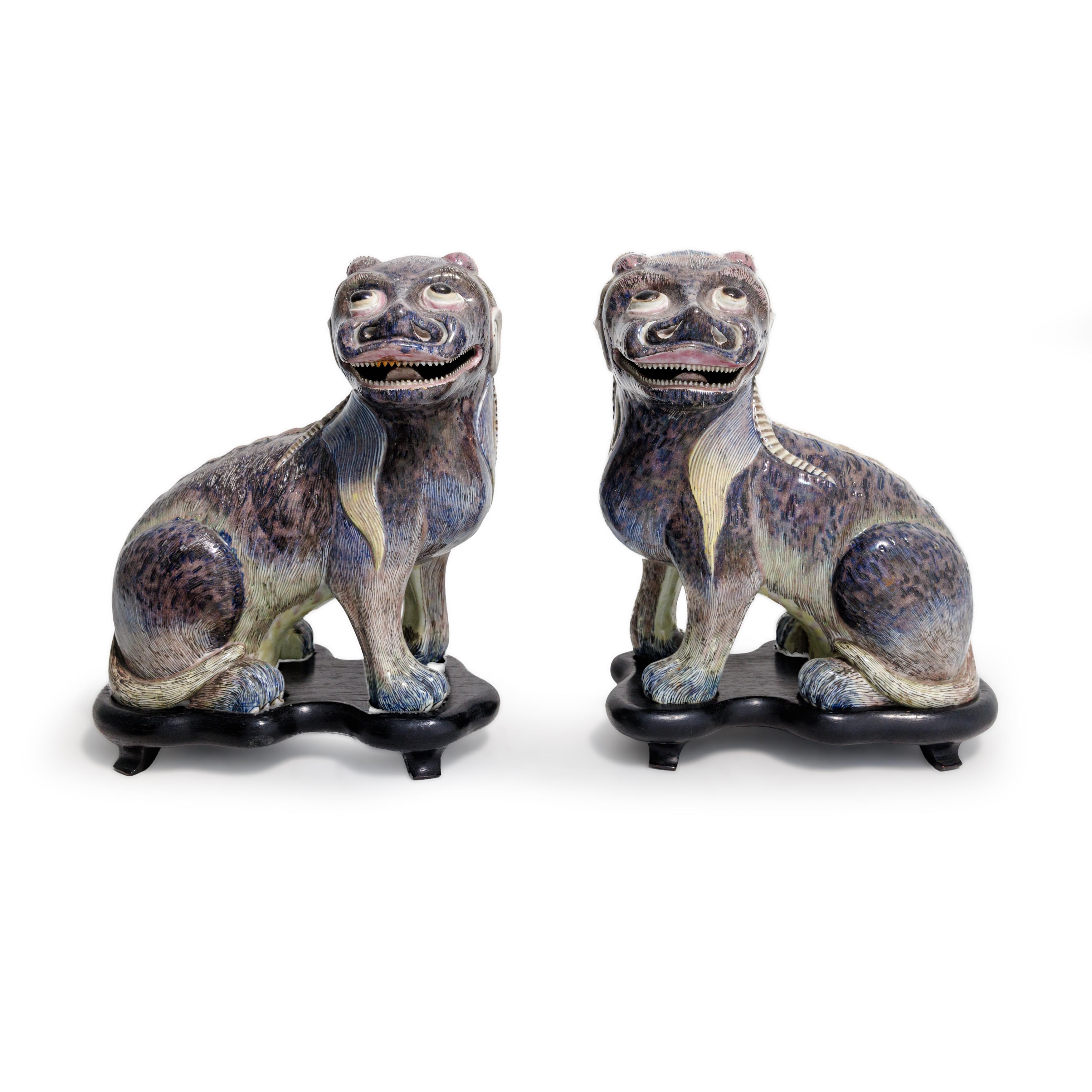 A pair of Chinese enamelled mythical beasts Qing dynasty, 19th century Of dog form with long, r...