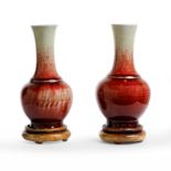 A pair of Chinese copper-red-glazed bottle vases Qing dynasty, 18th/19th century Each sturdily ...