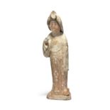 A Chinese pottery figure of a court lady Tang dynasty Modelled standing with the right hand rai...
