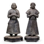 Two Chinese grey stoneware figures of attendants Western Xia dynasty Each standing with their h...