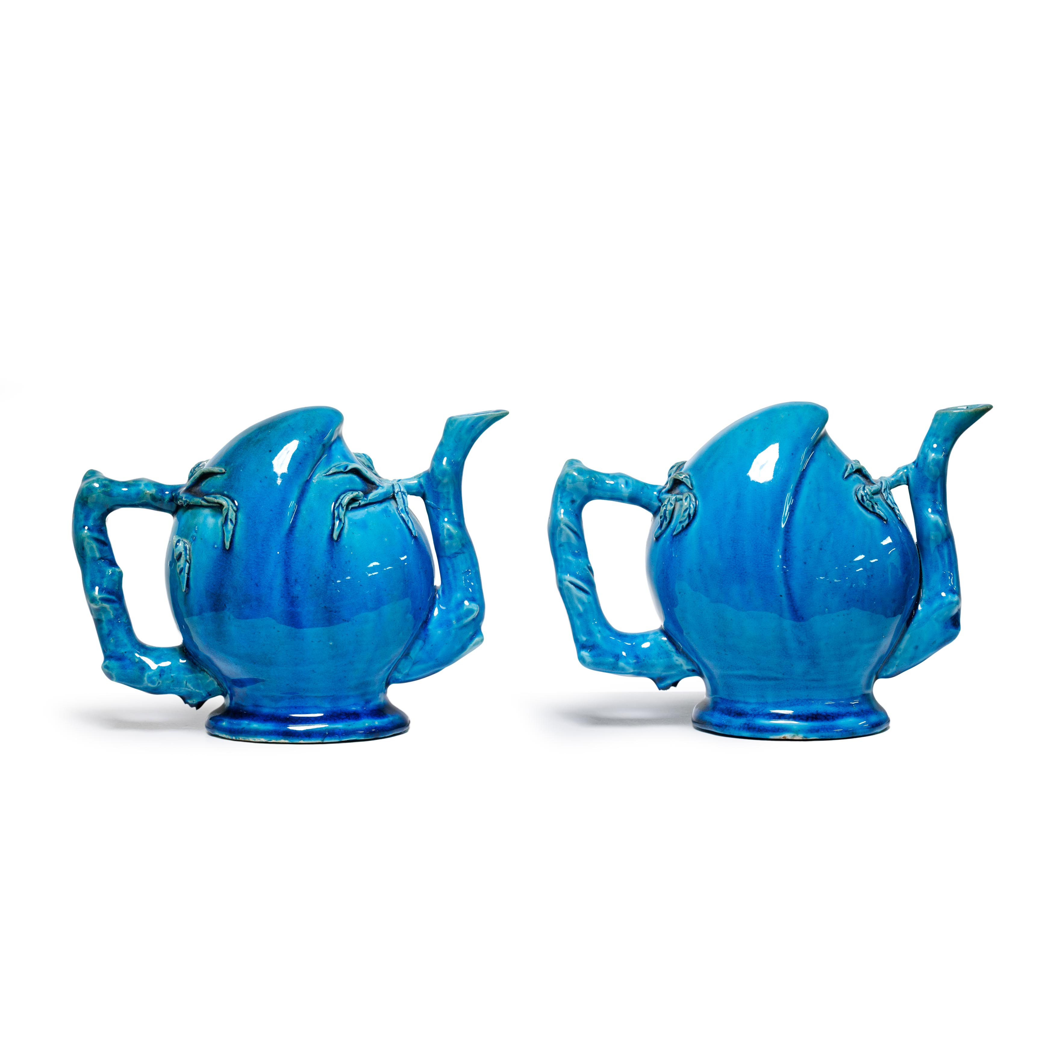 Two Chinese monochrome turquoise glazed peach form Cadogan teapots, Qing dynasty, 19th century ...