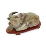 A massive Chinese jade buffalo, 20th century, The recumbent buffalo carved with legs tucked under...