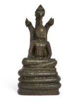 A Burmese bronze figure of Buddha Nagaraja, 19th century, Seated in dhyanasana beneath a three-he...