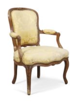 A French walnut fauteuil, Of Louis XV style, last quarter 19th century, With yellow silk damask u...