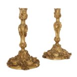 A pair of French gilt-bronze candlesticks, Of Louis XV style, late 19th century, Each cast with s...