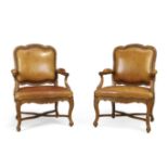 A pair of French walnut fauteuils, Of Regence style, first quarter 19th century, Each with carved...