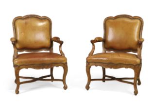A pair of French walnut fauteuils, Of Regence style, first quarter 19th century, Each with carved...