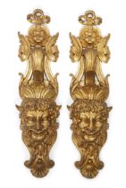 A pair of French gilt-bronze mask mounts, Of Regence style, second half 19th century, Cast as sat...