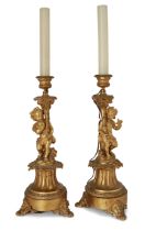 A pair of French gilt-bronze figural candlesticks converted to lamps,  Late 19th century,  Each m...