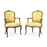 A near pair of French walnut fauteuils, Of Louis XV style, last quarter 19th century, With yellow...