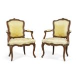 A pair of Louis XV beech framed fauteuils, Third quarter 18th century, With carved floral crest a...