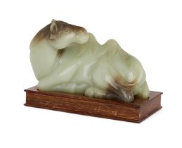 A Chinese Ming style celadon jade figure of a recumbent camel, 20th century, Carved with its head...