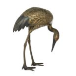 A Japanese bronze crane, Meiji period, late 19th century, Modelled with head bowed, traces of gil...