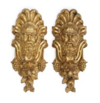 A pair of French ormolu mask mounts, 19th century, Cast as satyr masks with scrolling foliate sur...