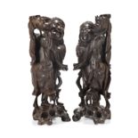 A pair of Chinese hardwood carved figural lamp bases, Early 20th century, Each carved as Liu Hai ...