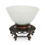 A Chinese pale green jadeite bowl, Early 20th century, The translucent stone with speckled dark g...