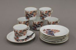 A set of six Japanese porcelain cups and saucers, decorated in the Imari palette. The saucers 14.