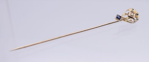 A gold diamond and sapphire stick pin, in box. 6.5 cm long. 1.1 gram total weight.
