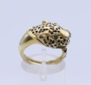 A 14 K gold gem set leopard mask form ring. Ring size N. 5.7 grammes total weight.