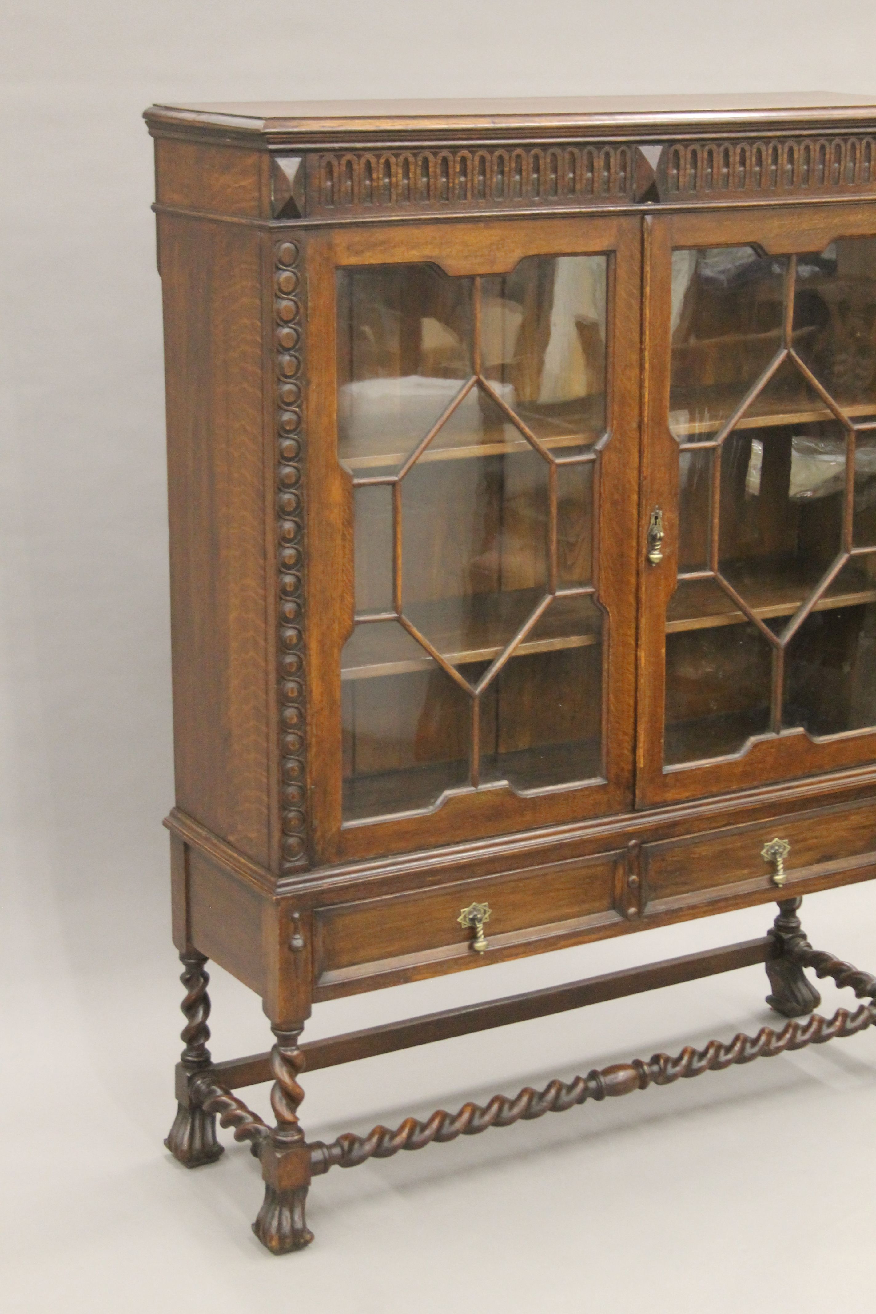 An early 20th century carved oak two door glazed barley twist cabinet. 105 cm wide. - Image 2 of 5