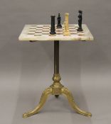 An onyx and brass chess table and a resin chess set. 46 cm square.