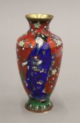A Japanese cloisonne vase decorated with a female figure in a garden. 13 cm high.