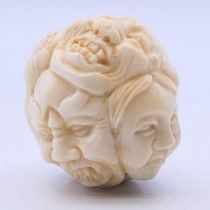 A bone carving of faces. 3.5 cm high.