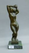 An Art Deco style bronze figure of a standing female nude on a green marble base. 32 cm high.
