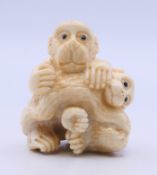 A bone carving of monkeys. 4 cm high.