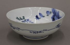 A late 19th/early 20th century Japanese blue and white bowl with green heightening. 18.